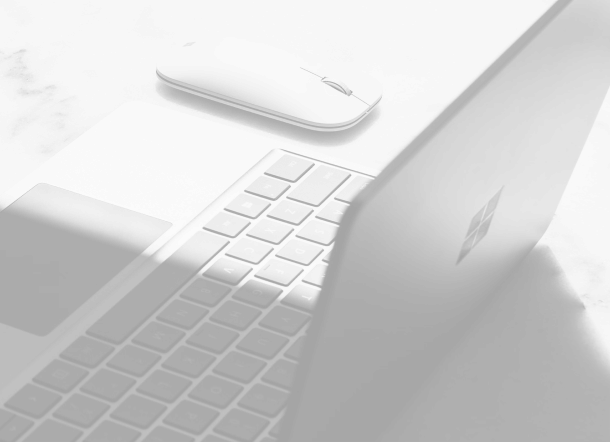 CloudMasonry Salesforce Consulting - Background Image - Laptop and wireless mouse on marble surface.
