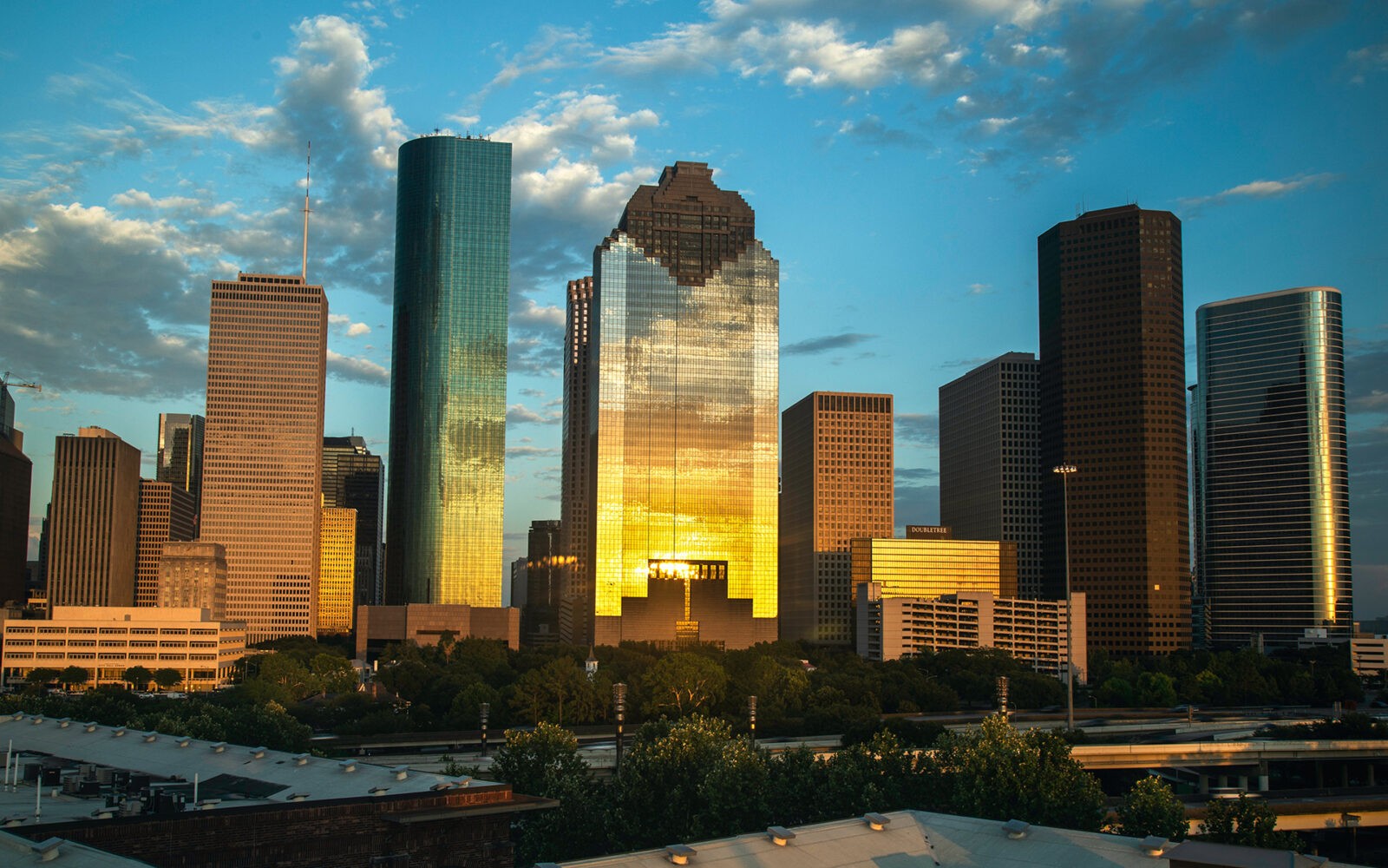 bg-houston2 CloudMasonry - Texas Based Salesforce Consulting - Houston Office Landing Page Image - Houston skyline at sunset with golden reflections.